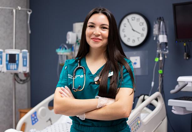 Lizbeth Mora Stands smiling in a nursing classroom